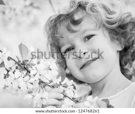 Happy child holding spring flower. Black and white, shallow depth of field