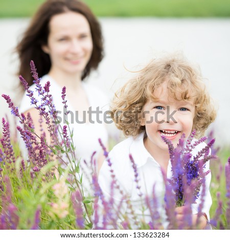 Happy child with bouquet of spring flowers outdoors. Mothers day concept