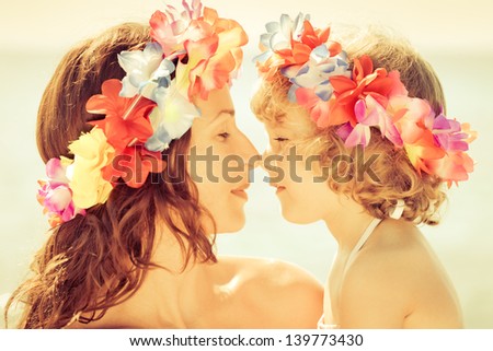 Woman And Child Wearing Hawaiian Flowers Garland On The Beach. Summer Vacations Concept