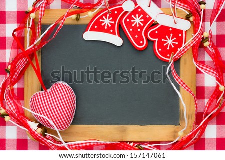 Vintage blackboard blank framed in red Christmas decorations. Winter holidays concept. Copy space for your text