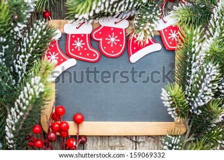 Blackboard blank framed in beautiful Christmas tree branches and decorations. Winter holidays concept. Copy space for your text