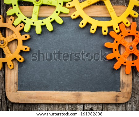 Elements of gear wheels on vintage wooden blackboard. Copy space for your text