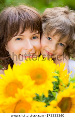Woman And Child With Bouquet Of Flowers Against Green Background. Spring Family Holiday Concept. Mother`S Day