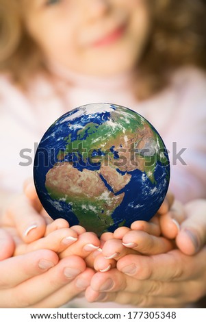 Family holding Earth in hands. Elements of this image furnished by NASA
