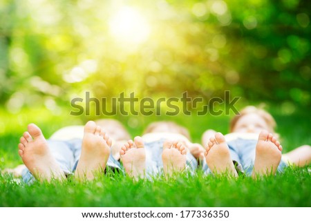Family Lying On Green Grass In Spring Park. Healthy Lifestyle Concept