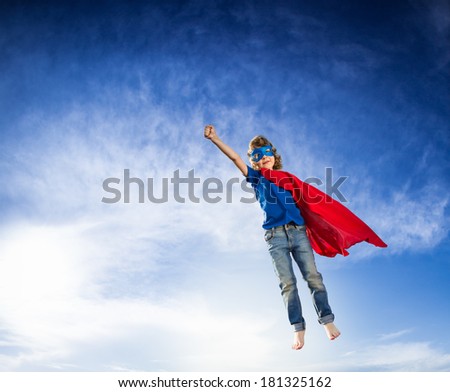 Superhero kid flying against dramatic blue sky background