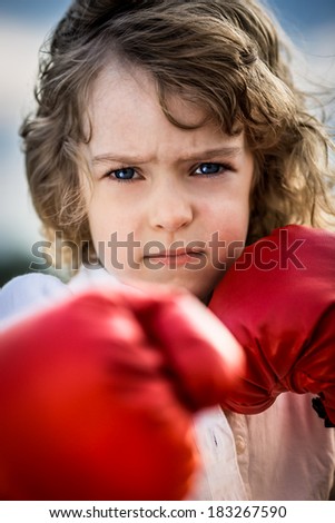 Kid wearing red boxing gloves