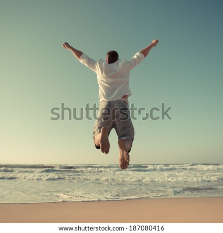 Funny man jumping at the beach. Travel and vacations concept