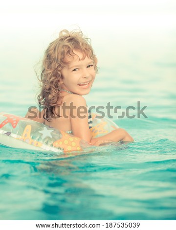 Happy child playing in swimming pool. Funny baby outdoors. Summer vacation concept