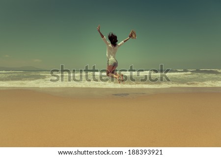 Happy woman jumping at the beach. Summer vacation concept