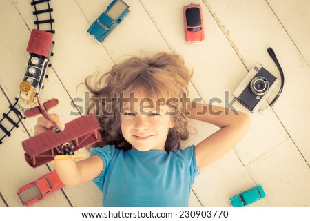 Child playing with vintage toys at home. Girl power and feminism concept