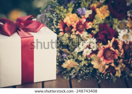 Gift box and flowers against spring background. Family holiday concept. Mothers day