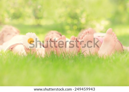 Happy family lying on green grass. Children having fun outdoors in spring park. Retro toned