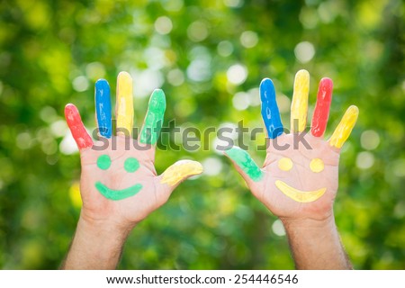 Smiley on hands against green spring background