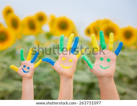 Happy family with smiley on hands against blue sky and yellow sunflower background