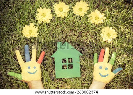 Group of happy people on green grass. Family having fun in spring. Smiley on hands. Ecology concept. Top view portrait. Retro toned image