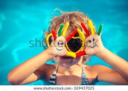 Funny child with drawing smiley on hands in swimming pool Summer vacation concept Funny child with drawing smiley on hands in swimming pool Summer vacation concept