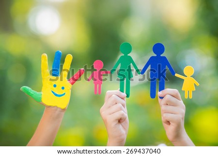 Paper family in hands against spring green background. Ecology concept