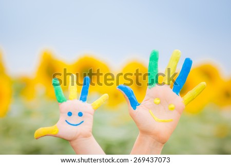 Happy family with smiley on hands against blue sky and yellow sunflower background