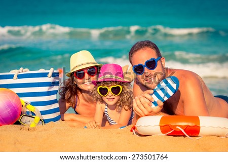 Happy family playing at the beach. Summer vacation concept