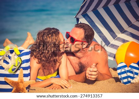 Happy couple in love. People lying on the beach. Young man and woman kissing. Summer vacation concept