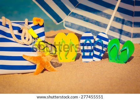Flip-flops, beach bag and funny starfish on the sand. Summer vacation concept
