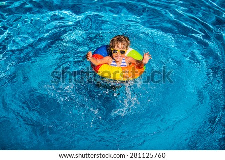 Happy child playing in swimming pool. Summer vacation concept. Top view portrait
