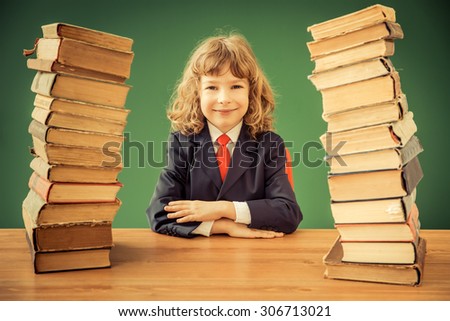 School kid in class. Happy child against green blackboard. Education concept