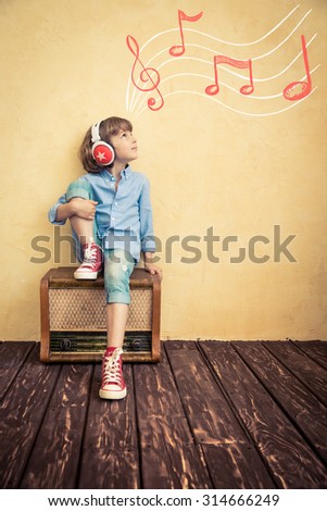 Kid listen music at home. Hipster child with retro vintage radio