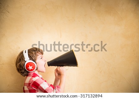 Kid listen music at home. Hipster child with retro vintage speaker