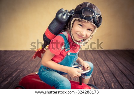 Kid with jet pack driving retro toy car. Child playing at home. Success, leader and winner concept