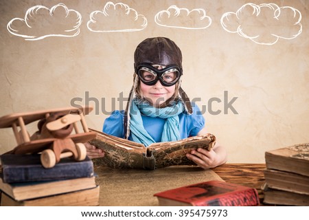 Child is pretending to be a pilot. Kid playing at home. Travel, freedom and imagination concept