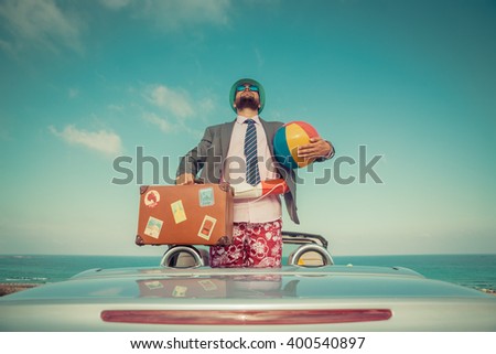 Successful young businessman on a beach. Man standing in the cabriolet classic car. Summer vacations and travel concept. Toned image