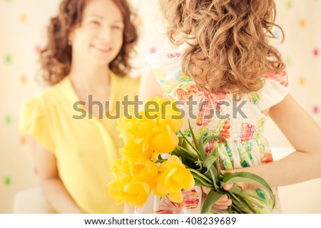 Woman and child with bouquet of flowers at home. Spring family holiday concept. Mother's day