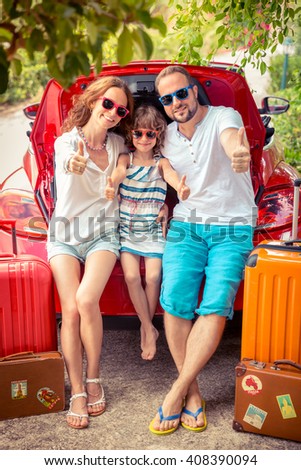 Happy family ready to trip. People standing near red car. Summer vacation and travel concept
