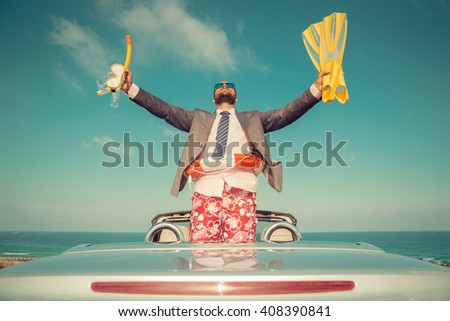 Successful young businessman on a beach. Man standing in the cabriolet classic car. Summer vacations and freedom travel concept. Toned image