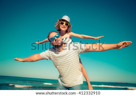 Father and child having fun on the beach. Summer vacation and travel concept