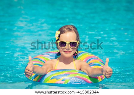 Funny portrait of child. Kid having fun in swimming pool outdoors. Summer vacation and healthy lifestyle concept