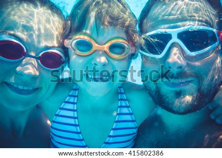 Family having fun in swimming pool. Underwater funny portrait. Summer vacation
