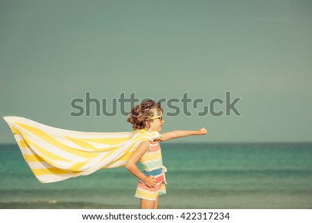 Child having fun on the beach against sea and sky background. Summer vacation and travel concept