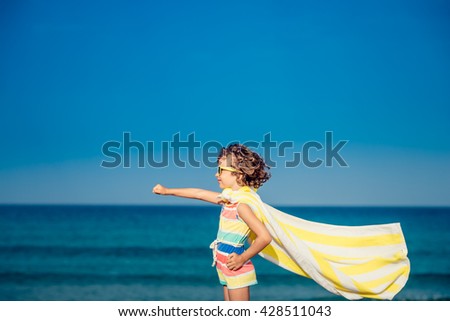 Child having fun on the beach against sea and sky background. Summer vacation and travel concept