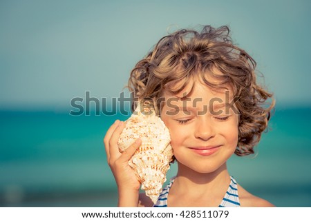 Child relaxing on the beach against sea and sky background. Summer vacation and travel concept