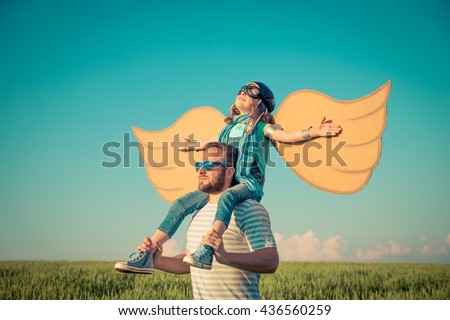 Happy kid playing with father. Dad and child outdoors. Family having fun. Happy family in summer field. Travel and vacation concept. Imagination and freedom concept