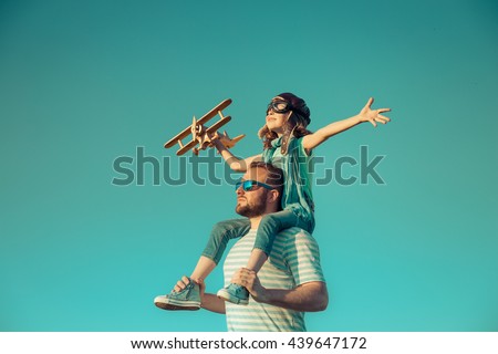 Happy kid playing with father. Dad and son outdoors. Father carrying child on his back. Happy family in summer field. Family having fun. Travel and vacation concept. Imagination and freedom concept
