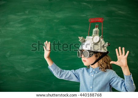 Back to school concept. School child with virtual reality headset. Kid in class. Nerd child in classroom. Funny geek kid against green blackboard. Innovation technology and education concept