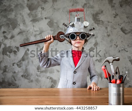 Portrait of geek child pretend to be businessman. Funny kid with toy virtual reality headset in modern loft office. Success, creative and innovation technology concept. Copy space for your text