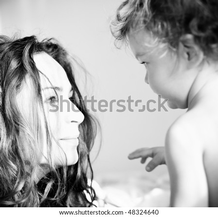 Portrait of the young woman and her baby girl executed in black-and-white style - shallow depth of field, focus on the woman