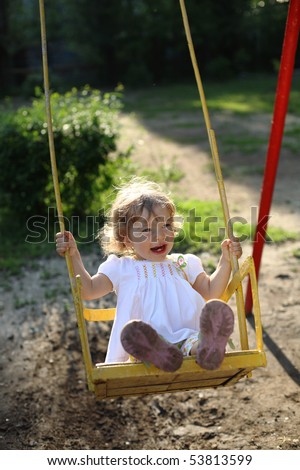 Playing on the swings after summer rain - shallow depth of field, back lighting
