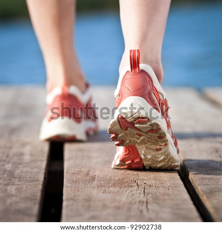 Feet of jogging person on wooden bridge