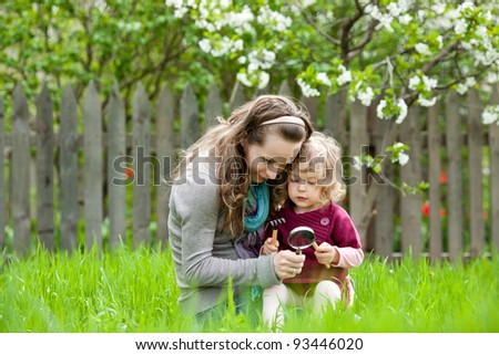 Happy family playing outdoors in spring garden against flowery background
